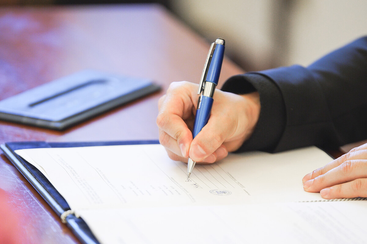 signature-contrat-pret-crayon-main-table
